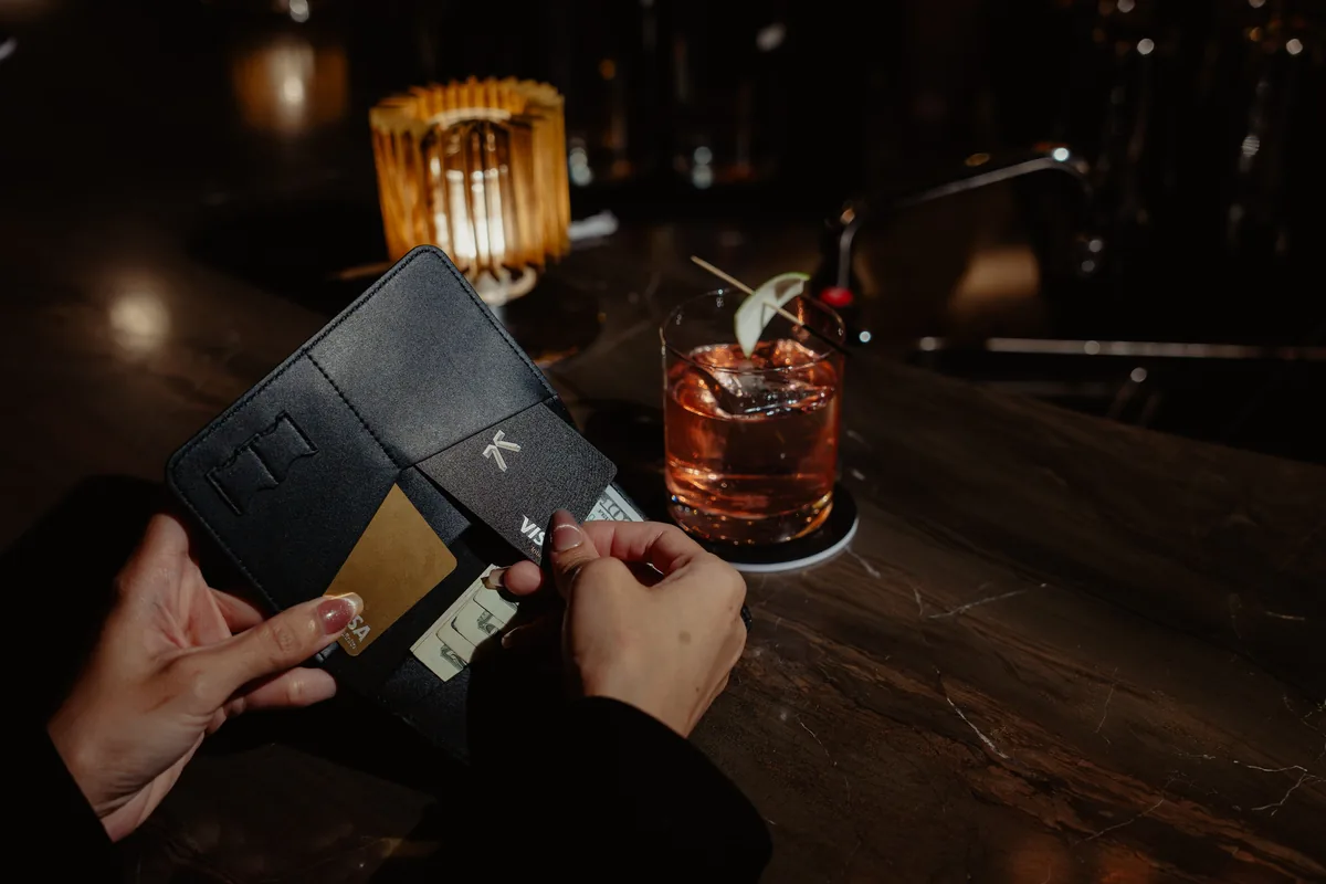 Taking a KAST card out of a wallet at a bar