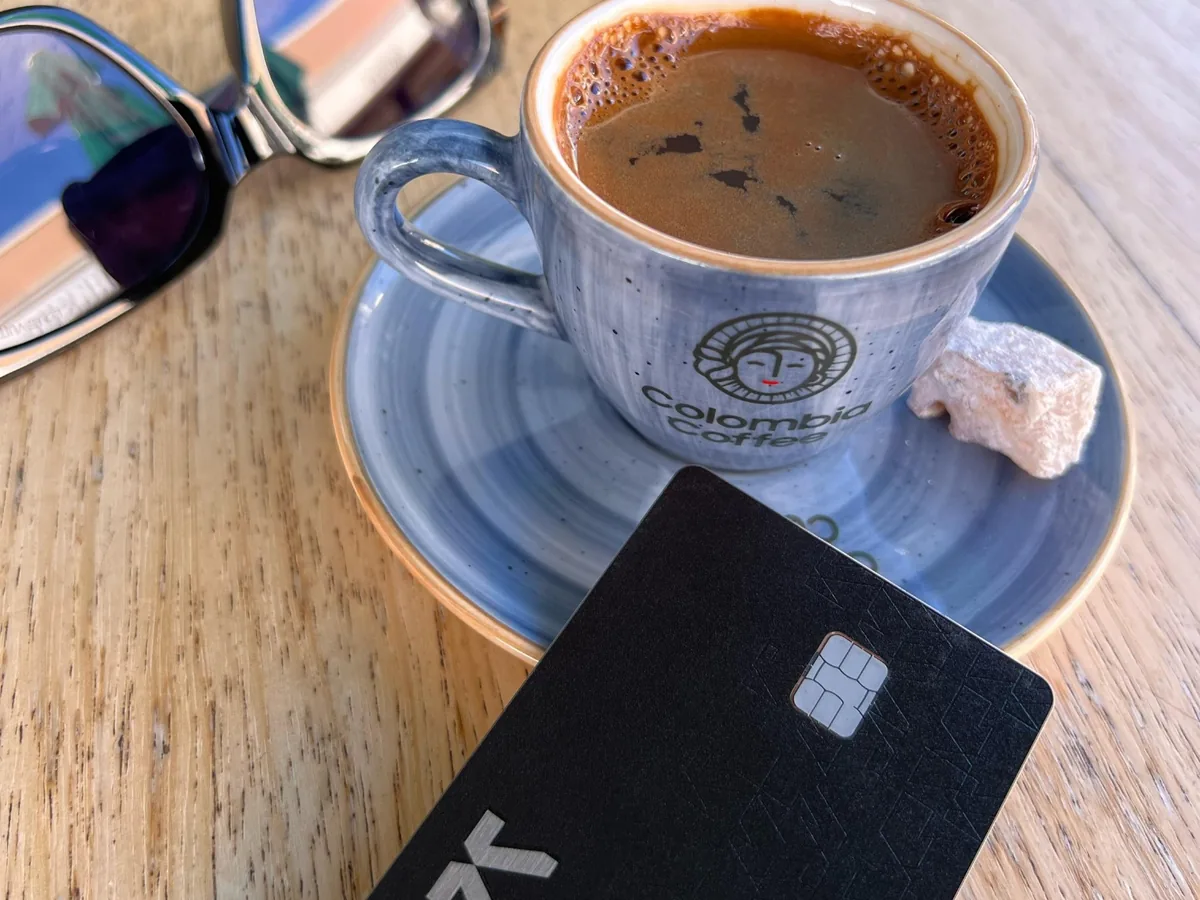 Black KAST card next to a Turkish coffee and sunglasses