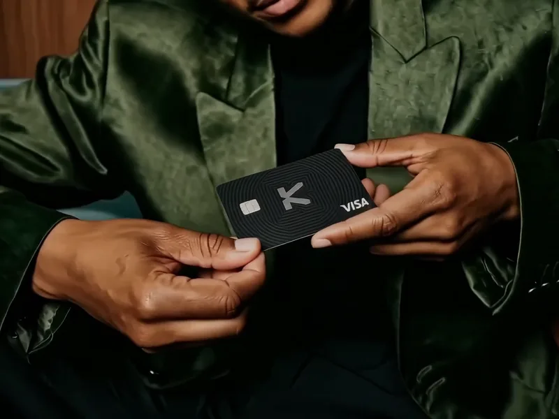 Hands holding a black KAST Visa card